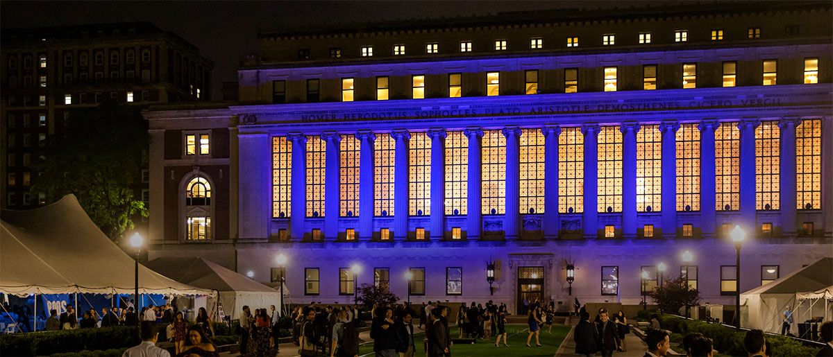 View of Butler Library and south lawns at night with party goers