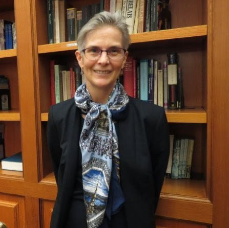 Dr. Deborah Martinsen standing in front of a bookcase