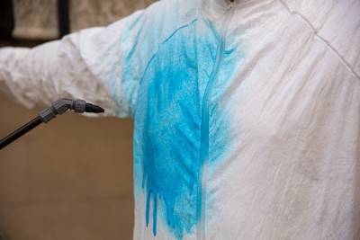 Highlight, a powder that you add directly into bleach before spraying, colors the bleach blue and helps it stick onto any surface. Here, Highlight is sprayed onto a PPE suit. Photo: Kyle Lee SEAS’17; courtesy Kevin Tyan CC’16