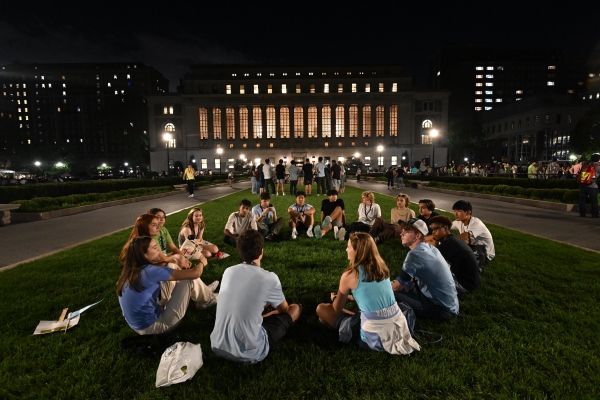 First-year students sit in a circle on the lawn in front of Butler Library before orientation begins