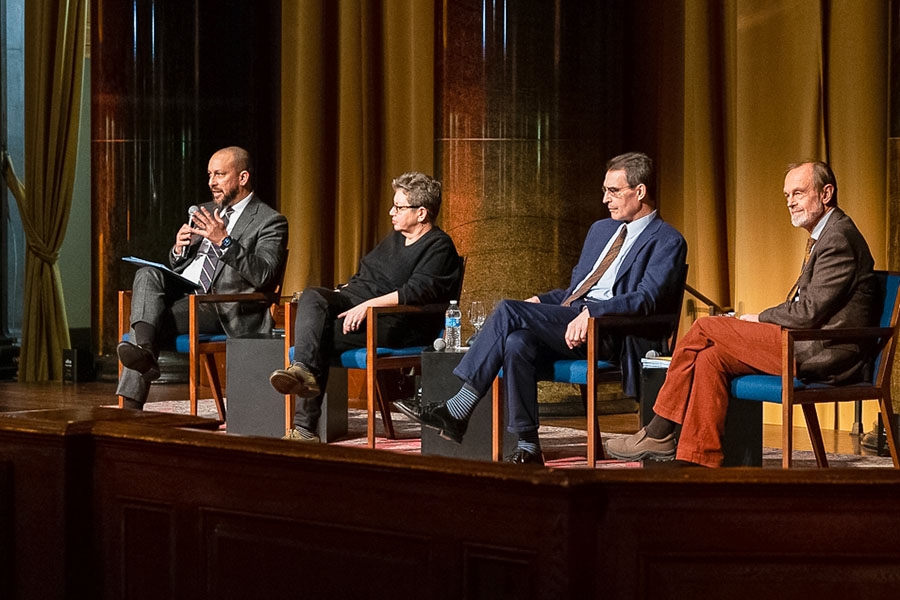 Panel of four speakers seated on stage in Low Library rotunda