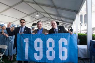 (Left to right) Hooman Mehran ’86, Rick Wolf ’86 and Mark Berman ’86 proudly carry their class banner in this year’s Alumni Parade of Classes at Class Day. Photo: Susan Cook