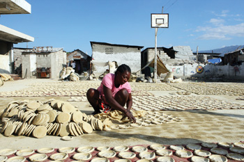 A woman makes food from dried clay in Cité Soleil, one of Haiti’s poorest slums. 