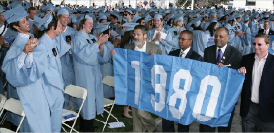 Students stood and cheered as members of the Class of 1980 passed by with their class banner during the Alumni Parade of Classes. 