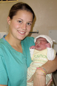 Mollie Andreae ’11 holds a newborn boy she helped deliver during her summer in South Africa. PHOTO: Lyndsey Foushee