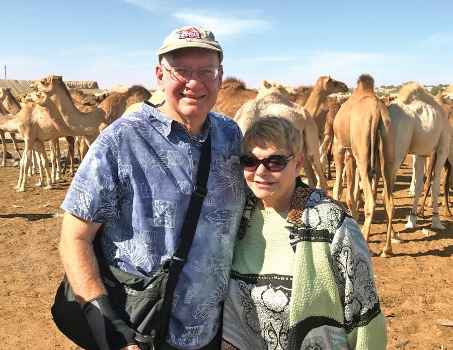 Rich Juro ’63, LAW’66 and his wife Fran Juro, in a desert setting with camels in the background
