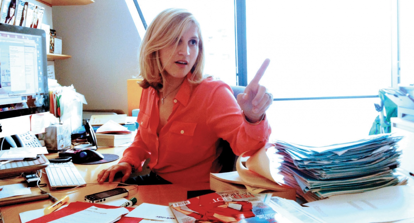 A woman in an orange shirt gesturing