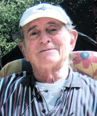 An elderly white man in a baseball cap smiling