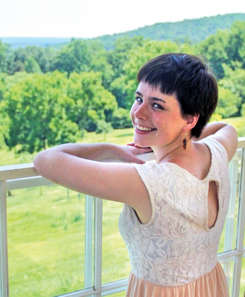 A dark-haired young woman, smiling over her shoulder