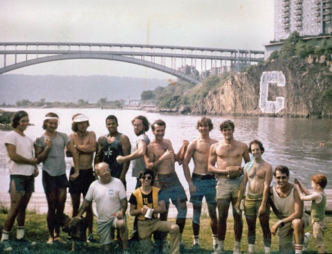 A group of young men on the bank of a river.