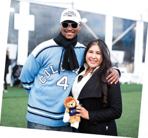 A man and woman smiling at the camera, wearing Columbia gear and holding  a Roar-ee stuffed lion