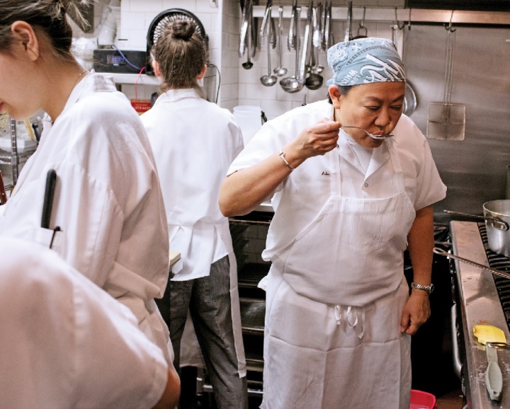 Anita Lo '88 tastes a dish in preparation.