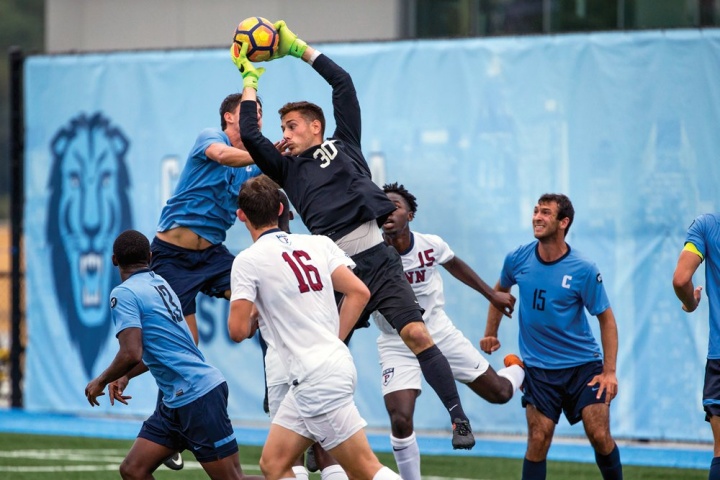 a soccer goalie grabbing a ball