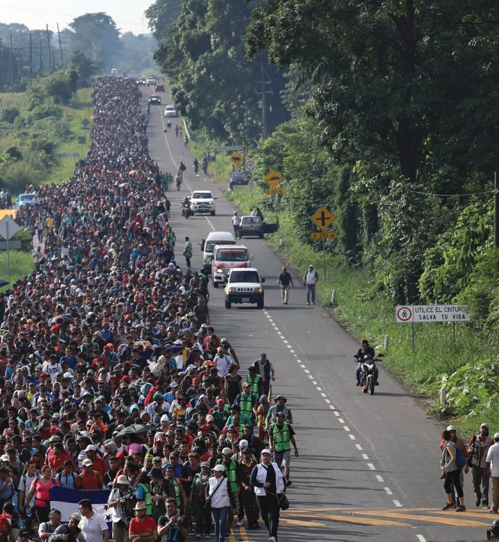 hundreds of people walking on a road