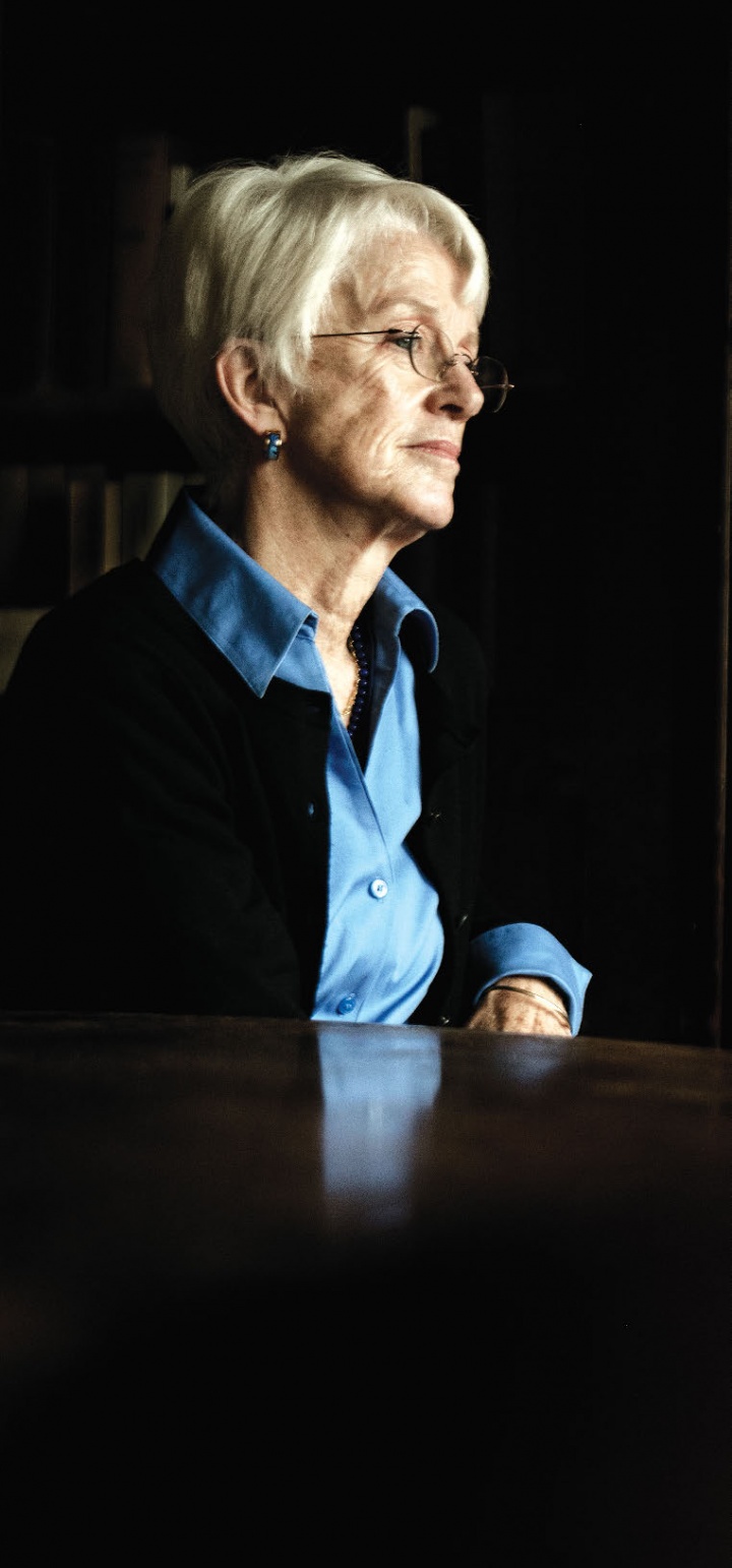 A white woman wearing glasses and a blue collared shirt