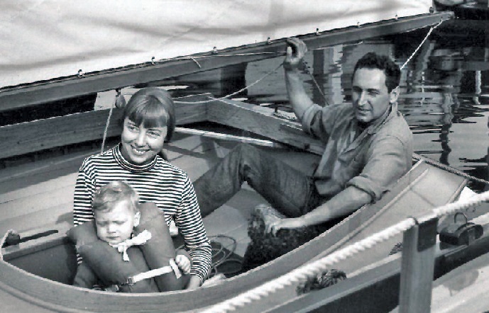 A black and white photograph of a young family on a boat