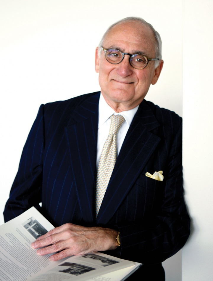 A white man in glasses and a suit and tie, with a yellow pocket square