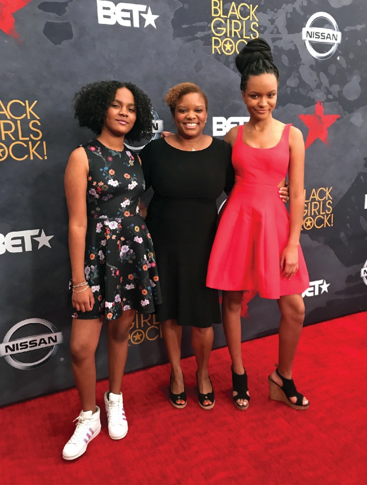 three black women on a red carpet