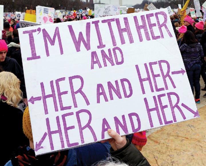 A sign reading "I'm with her and her and her and her"