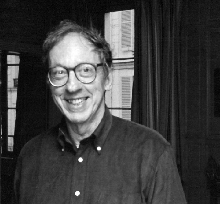 a blurry black-and-white photo of a man wearing glasses