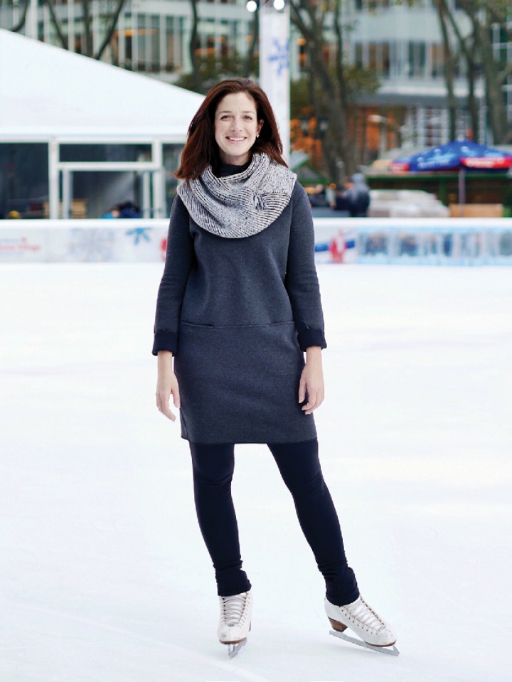 A woman standing skates on an ice rink