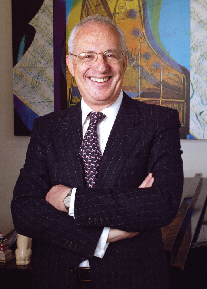 A white man in a suit with his arms crossed