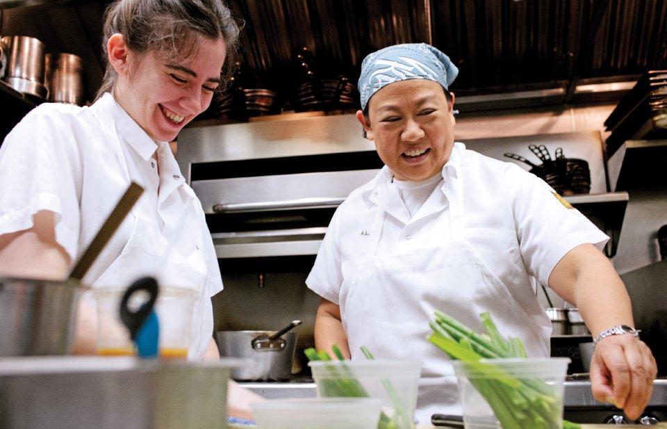 Anita Lo '88 works in the kitchen alongside a fellow chef.