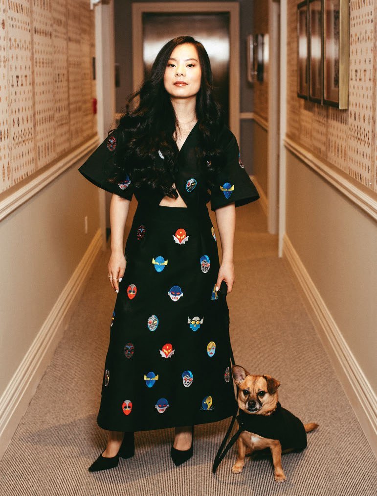 Noël Duan ’13 standing in a hallway with a small dog.