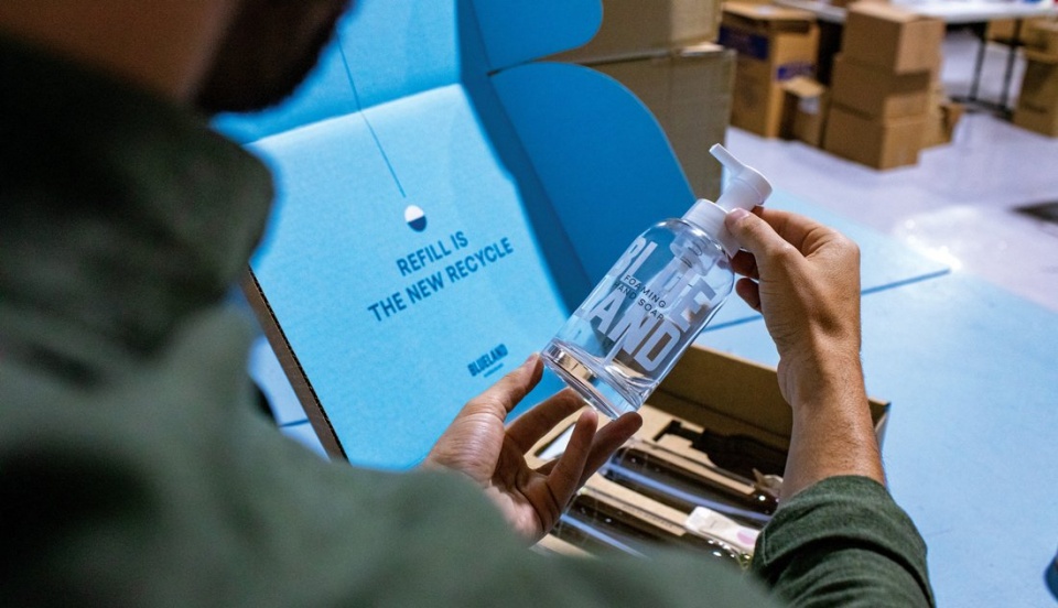 A man holding a bottle marked with the words "Blue Land"