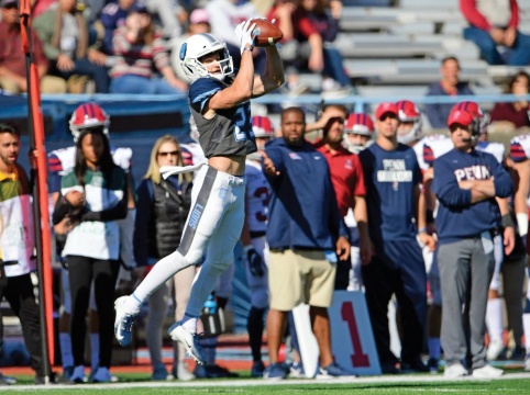 Columbia Lions football player in the air after catching a football.