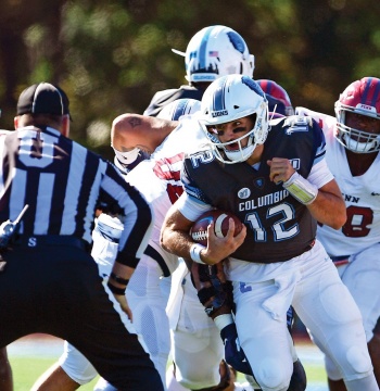 A Columbia Lions football player with jersey # 12 running with the ball.