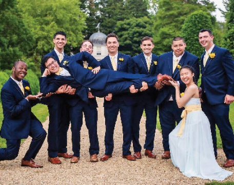 Men in blue suits holding another man in a suit, a woman in a pale blue dress