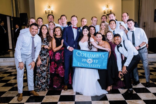 wedding party with Columbia banner