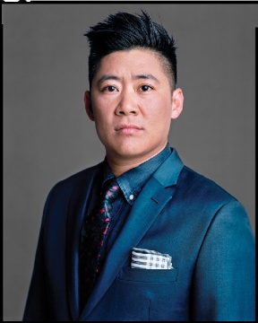 An Asian man in a blue suit with a pocket square