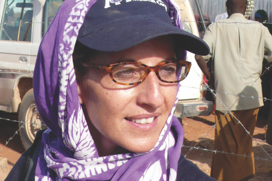 A white woman in a purple baseball cap