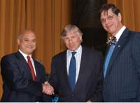 Geoffrey J. Colvin ’74 (left)
                        is congratulated by President Lee C. Bollinger ’71L as Alumni 
						Federation President Paul M. Thompson ’74 GSAS, ’77 GSAS looks
						on.