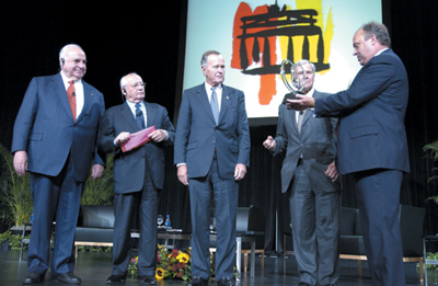 Tom Harrold '66 
                    presents an award at The Unification Conference.