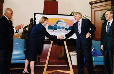 President Lee C. Bollinger shakes hands with Donna Peak, V.P. of the U.S. Postal Service