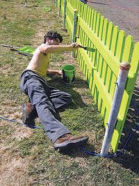 Photo of Mike Agresta painting a fence