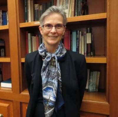 Dr. Deborah Martinsen standing in front of a bookcase