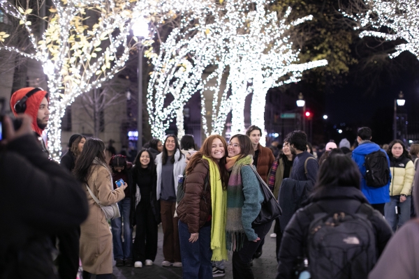 Students pose on College Walk after the trees are lit.