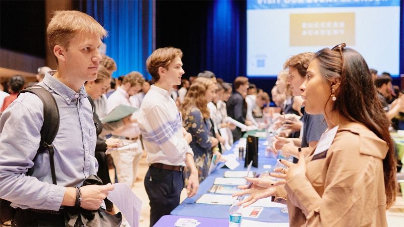 Students and employers in discussion across tables at a CCE career fair