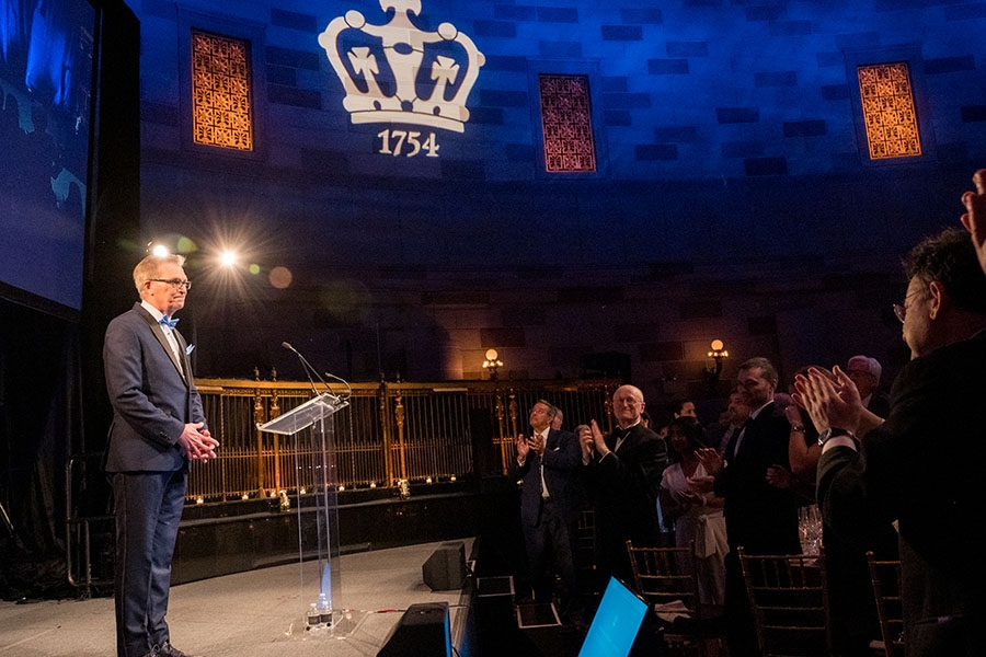 Dean James Valentini receives applause while onstage at an event
