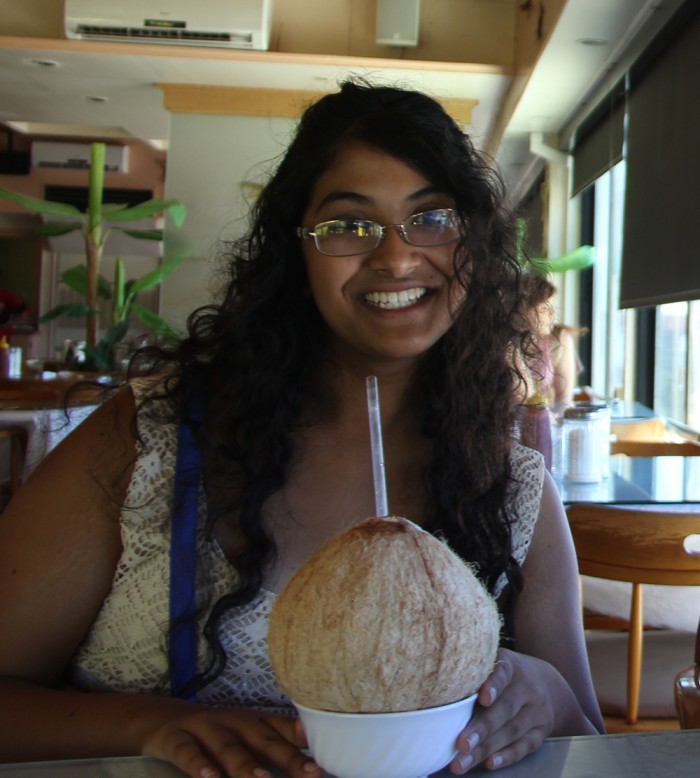 Asha Banerjee CC’17 drinking coconut water in its shell at the Tide Table Restaurant in Hotel Robert Reimers, Majuro Atoll. Photo: Courtesy Asha Banerjee CC’17